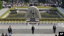 PM Jepang Shinzo Abe (tengah) memimpin upacara peringatan 68 tahun peristiwa bom aton di Hiroshima dari depan tugu peringatan di Taman Perdamaian Hiroshima yang didirikan di dekat pusat ledakan bom tersebut untuk mengenang para korban (6/8).