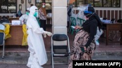 Seorang ibu hamil datang untuk tes swab virus corona COVID-19 di Surabaya pada 21 Juli 2020. (Foto: AFP/Juni Kriswanto)