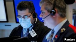 FILE - Traders work on the floor of the New York Stock Exchange (NYSE) in New York, March 20, 2020. 