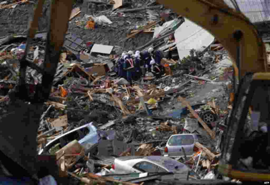 Police officers carry the body of a victim in Rikuzentakata, Iwate Prefecture, Japan, Monday, March 14, 2011, three days after northeastern coastal towns were devastated by an earthquake and tsunami. (AP Photo/Itsuo Inouye)