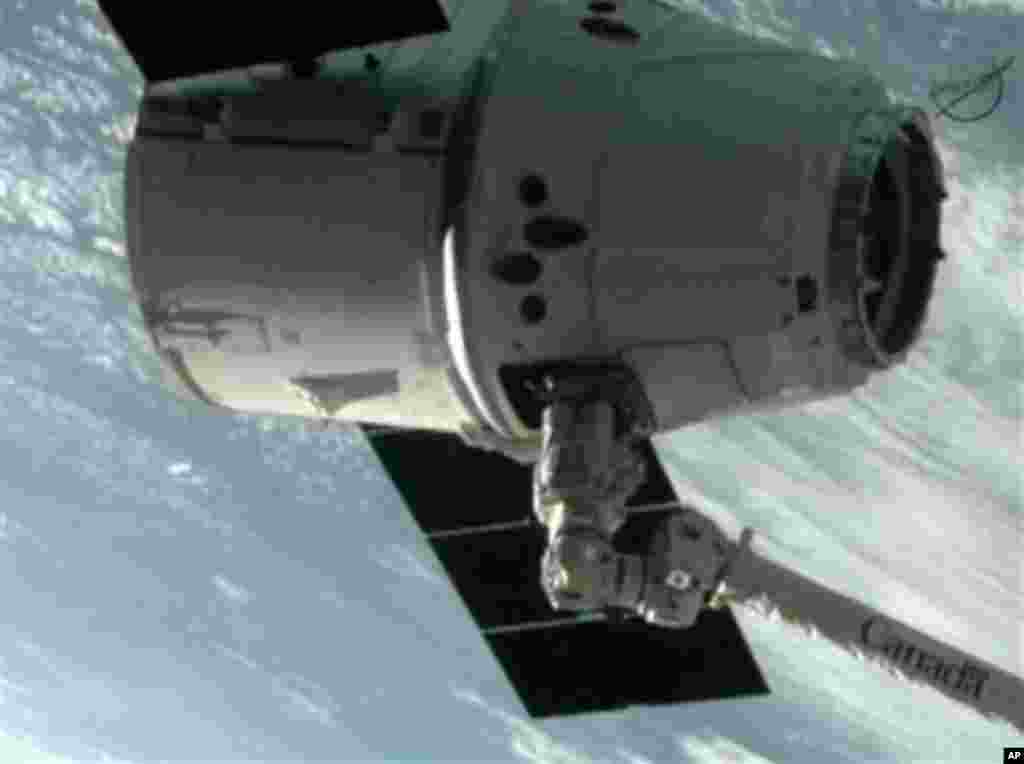 This image provided by NASA-TV shows the SpaceX Dragon commercial cargo craft after Dragon was grappled by the Canadarm2 robotic arm and connected to the International Space Station, Friday, May 25, 2012. Dragon is scheduled to spend about a week docked w