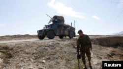 FILE - An Afghan National Army (ANA) soldier searches for mines during a patrol in Logar province, Afghanistan, February 16, 2016.