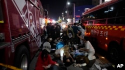 FILE - Injured people are helped at a street near the scene of a crush in Seoul, South Korea, on Oct. 30, 2022. 