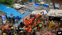 Rescuers look for survivors after a wall collapsed on several slum houses heavy monsoon rains in the Mahul area of Mumbai, India, July 18, 2021.