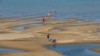 FILE - Sightseers play on a sandbar in the Mekong River in Nakhon Phanom province, northeastern Thailand, Dec. 4, 2019. 