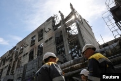 Los empleados de la central térmica aparecen en el edificio dañado por los recientes ataques con misiles rusos, en medio del ataque de Rusia a Ucrania, en un lugar no revelado en el oeste de Ucrania el 2 de mayo de 2024. REUTERS/Roman Baluk