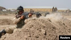 FILE - Iraqi soldiers train with members of the U.S. Army 3rd Brigade Combat Team, 82nd Airborne Division, at Camp Taji, Iraq, in this U.S. Army photo released June 2, 2015. 