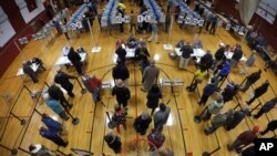 Voters wait in line in the gymnasium at Brunswick Junior High School to receive their ballots for the midterm election in Brunswick, Maine, Nov. 6, 2018. 