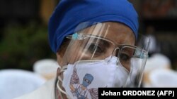 一位危地马拉城的医护人员哀悼因新冠病毒死亡的同事（2020年10月9号）。