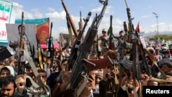 Protesters, largely Houthi supporters, hold rifles as they rally to show solidarity with Palestinians in Gaza, in Sanaa, Yemen, May 10, 2024. 