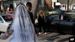 FILE - In this April 18, 2020 file photo, a policeman asks a bride and groom to leave the waterfront promenade where they had decided to take some pictures, in Beirut, Lebanon. 