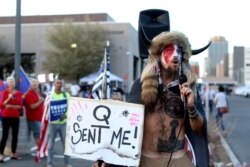 FILE - In this Nov. 5, 2020, file photo, Jacob Anthony Chansley, who also goes by the name Jake Angeli, a Qanon believer speaks to a crowd of President Donald Trump supporters outside of the Maricopa County Recorder's Office where votes in the…