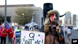 FILE - In this Nov. 5, 2020, file photo, Jacob Anthony Chansley, who also goes by the name Jake Angeli, a Qanon believer speaks to a crowd of President Donald Trump supporters outside of the Maricopa County Recorder's Office where votes in the…