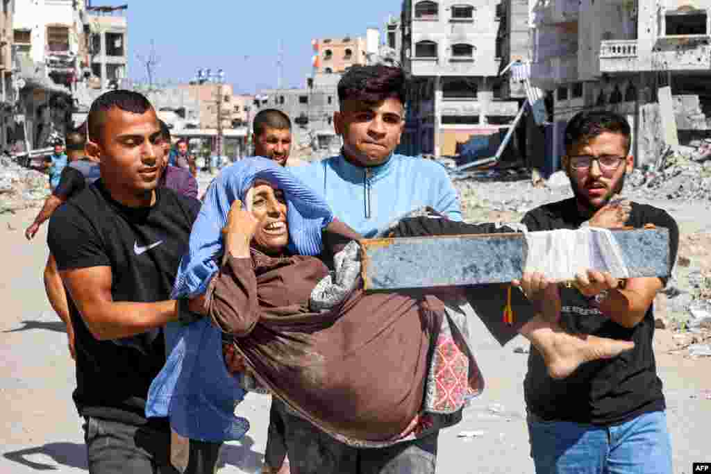 Men carry an injured woman to be evacuated in the Jabalia camp for Palestinian refugees in the northern Gaza Strip.