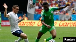 Le Nigérian John Obi Mikel en duel avec le Français Mathieu Debuchy lors de la Coupe du monde de football de 2014 au stade national de Brasilia à Brasilia le 30 juin 2014