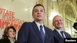 FILE - Sorin Grindeanu, center, answers a question during a press conference in Bucharest, Romania Dec. 28, 2016.