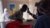FILE - A suspected COVID-19 patient has his temperature taken as he is admitted at the isolation ward of Ministry of Health Infectious Disease Unit in Juba, South Sudan, April 24, 2020.