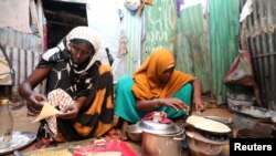An internally displaced Somali woman and her daughter prepare their Iftar meal during the month of Ramadan at the Shabelle makeshift camp in the Hodan district of Mogadishu, Somalia, May 8, 2020.