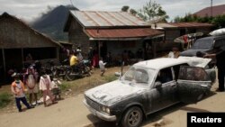 Warga desa berdiri di dekat mobil yang diselimuti debu, menunggu untuk dievakuasi, sementara gunung Sinabung di Karo, Sumatera Utara terus mengeluarkan debu dan lava panas(15/9).