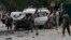 Afghan policemen investigate the site of a suicide attack in Kabul, June 6, 2014.