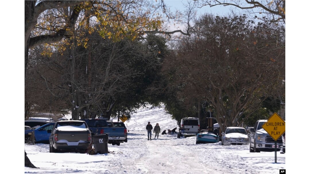 People walk from the snow-covered Mississippi River levee the day after a rare and record-setting snowstorm in Harahan, Louisiana, Jan. 22, 2025. (AP Photo/Gerald Herbert)