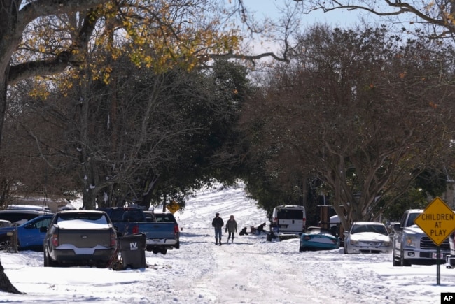 People walk from the snow-covered Mississippi River levee the day after a rare and record-setting snowstorm in Harahan, Louisiana, Jan. 22, 2025. (AP Photo/Gerald Herbert)