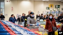 People wear masks at a supermarket in Milan, Italy, March 8, 2020.