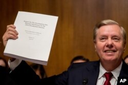 Chairman Sen. Lindsey Graham, R-S.C., holds up a copy of the Mueller Report during a Senate Judiciary Committee hearing on Capitol Hill in Washington, May 1, 2019.