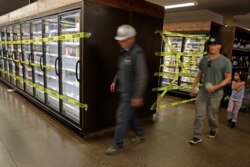 Customers walk past off-limits frozen foods section of Big John's Market in Healdsburg, Calif., shortly after it reopened, Oct. 31, 2019. Power was restored to the family-owned grocery store late Tuesday after being four days.