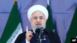 Iran's President Hassan Rouhani speaks at a military parade marking the 38th anniversary of Iraq's 1980 invasion of Iran, in front of the shrine of the late revolutionary founder, Ayatollah Khomeini, outside Tehran, Iran, Saturday, Sept. 22, 2018. 