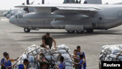 Personel militer Filipina dan AS bersiap memasukkan barang-barang bantuan untuk korban Topan Haiyan ke pesawat militer milik Amerika di Basis Angkatan Udara Villamor, Filipina.