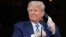 USA, Washington, U.S. President Donald Trump takes off his face mask as he comes out on a White House balcony