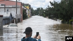 Muškarac fotografiše ulicu koju je poplavila rijeka Opava 15. septembra 2024. u Opavi, Češka.