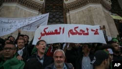 People chanting slogans raise banners rejecting military rule during a demonstration in Algiers, Algeria, April 10, 2019. 