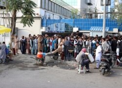 Afghans wait in long lines for hours to try to withdraw money, in front of Bank in Kabul, Afghanistan, Aug. 30, 2021. The Taliban have limited weekly withdrawals to $200.