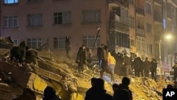 Sejumlah warga tampak berusaha mencari orang-orang yang masih terperangkap di dalam reruntuhan gedung di Pazarcik, Turki, setelah gempa besar mengguncang wilayah tersebut pada 6 Februari 2023. (Foto: Depo Photos via AP)