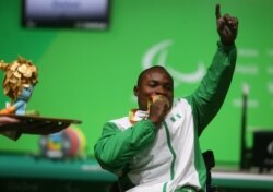 FILE - Roland Ezuruike of Nigeria kisses his gold medal following the men's Paralympic Powerlifting competition, Rio de Janeiro, Brazil, Sept. 9, 2016.