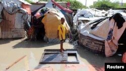FILE - A Somali boy stands on a wooden cupboard after heavy rain flooded the neighborhood in Mogadishu, Somalia, Oct. 21, 2019. 