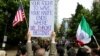 An “anti-hate” rally participant holds a sign in front of a competing “free-speech” rally across the street in downtown Portland, June 2017. (R. Taylor/VOA)