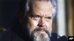 FILE - Actor and film director Orson Welles poses for photographers during a press conference in Paris, Feb. 22, 1982.