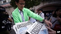 Seorang pria membagikan edisi ekstra koran yang melaporkan peluncuran misil Korea Utara di stasiun Shimbashi di Tokyo, 15 September 2017. 