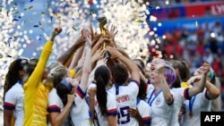 FILE - US players celebrate with the trophy after the France 2019 Women’s World Cup football final match between USA and the Netherlands, July 7, 2019, at the Lyon Stadium in Lyon, central-eastern France.