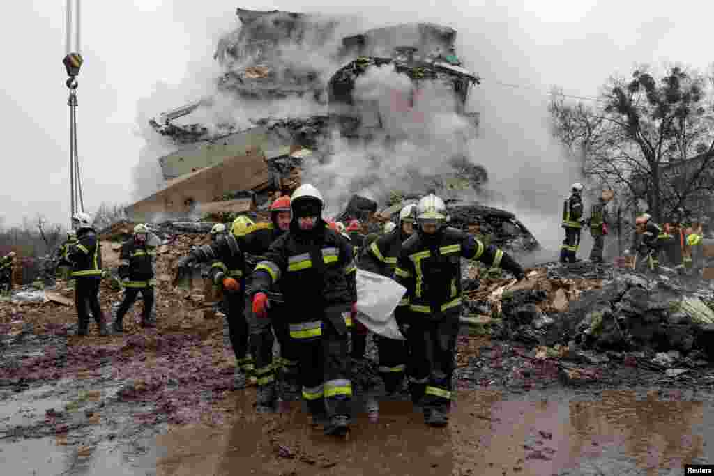 Rescuers carry the body of a person found under debris at the site of an apartment building hit by a Russian missile strike in Poltava, Ukraine, Feb. 1, 2025.