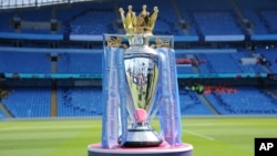 FILE - The English Premier League trophy is displayed on the pitch prior to the English Premier League soccer match between Manchester City and Huddersfield Town at Etihad stadium in Manchester, England, May 6, 2018.