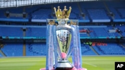 FILE - The English Premier League trophy is displayed on the pitch prior to the English Premier League soccer match between Manchester City and Huddersfield Town at Etihad stadium in Manchester, England, May 6, 2018.