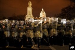 FILE - District of Columbia National Guard stand outside the Capitol, January 6, 2021, after a day of rioting protesters.