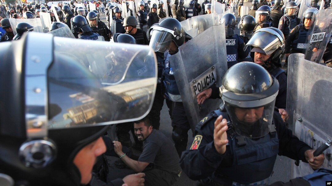 Polisi paksa demonstran yang memblokir jalan utama selama sekitar satu jam karena mereka memprotes kenaikan harga gas di Mexico City, 4 Januari 2017. (AP Photo/Marco Ugarte). 