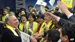 Kazakh President Nursultan Nazarbayev (L) greets supporters during the "Forward, together with the leader" forum in Astana, April 4, 2011