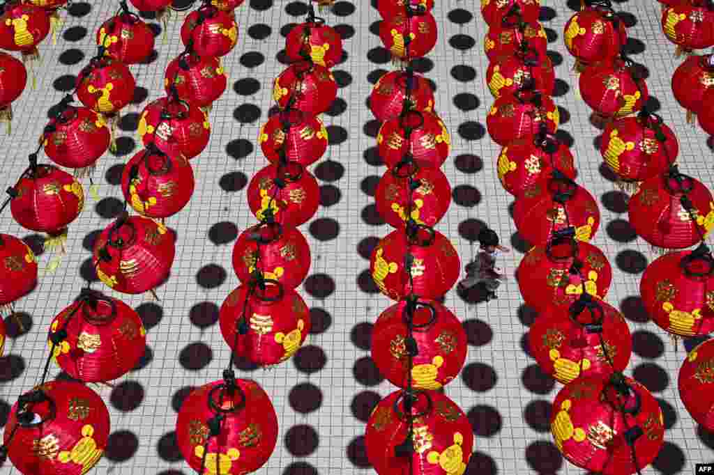 A boy plays under traditional Chinese lanterns decorations at the Thean Hou Temple ahead of Lunar New Year celebrations, in Kuala Lumpur, Malaysia.