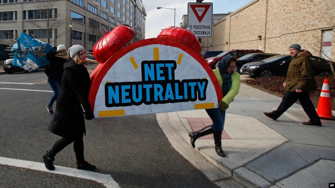Demonstranti nose simbolični budilnik na kome piše "Neutralnost interneta" na protestu ispred Federalne komisije za komunikacije u Vašingtonu.